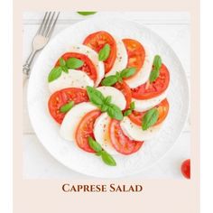 caprese salad with mozzarella and basil on a white plate next to a fork