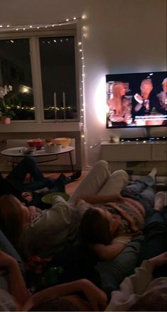 group of people laying on the floor watching tv