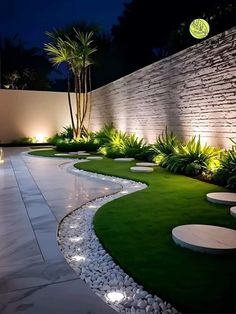 an outdoor garden at night with lights on the wall and grass in the ground,