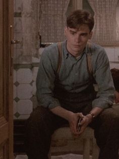 a young man sitting on top of a chair