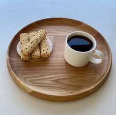 a wooden plate topped with cookies and a cup of coffee