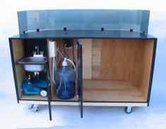 an open cabinet with some bottles and other items in it's storage compartment on wheels