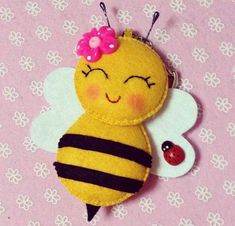 a yellow and black bee with a pink flower on its head sitting on a pink background