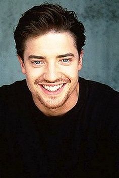 a smiling man with blue eyes wearing a black shirt