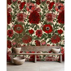 a bench sitting in front of a wallpaper with red flowers and leaves on it