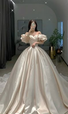 a woman in a white wedding dress is posing for the camera with her hands on her face