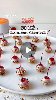 small desserts are arranged on a white plate with red cherries and drizzled