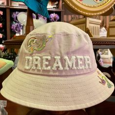 Disney Parks Princess Dreamer Lilac-Lavender Bucket Hat. Adorable And Super Cute Princess Dreamer Theme Bucket Hat. Lilac-Lavender Color. Fuzzy White "Dreamer" Lettering. Holographic Ariel With Rainbow. Cinderella Crown And Slipper. Belle's Rose. New With Tags! * One Size * Shell: 100% Cotton * Lining: 95% Polyester, 5% Cotton Smoke Free Home Cinderella Crown, Monsters University Hat, Mickey Mouse Ears Hat, Mermaid Hat, Blue Bucket Hat, Blue Stockings, Disney Minnie Mouse Ears, New Disney Princesses, Christmas Beanie