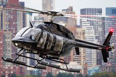 a helicopter flying over a city with tall buildings in the backgroung area