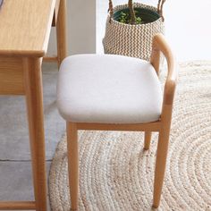 a chair with a plant in it next to a table