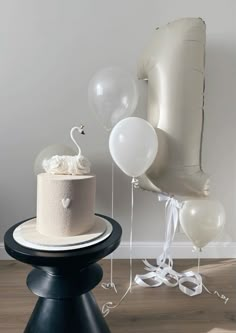 there is a cake and balloons on the table