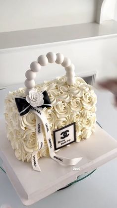 a cake that is shaped like a purse with roses on it and a ribbon around the handle