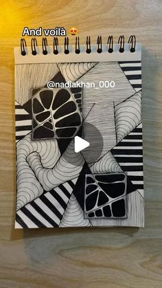 a spiral notebook with black and white designs on it