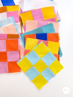 several pieces of colored paper laid out on top of each other, including squares and rectangles