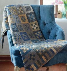 a blue chair with a quilt on it