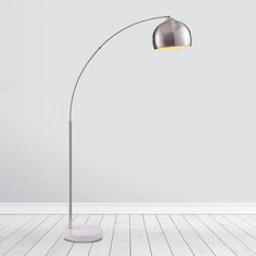 a modern floor lamp in an empty room with white walls and wooden floors, the light is