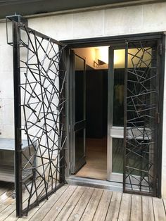 an open door on the outside of a building with wood flooring and glass doors