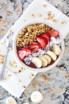 a bowl filled with granola and sliced bananas