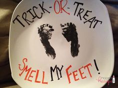 a white plate with handprints on it that says trick or treat smell my feet