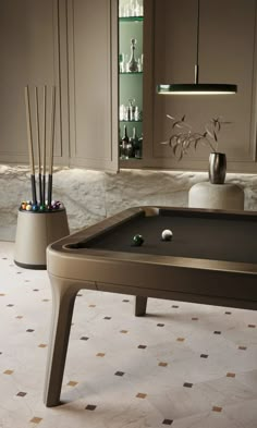 a pool table in the middle of a room with some candles on top of it