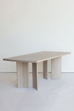 a wooden table sitting on top of a white floor