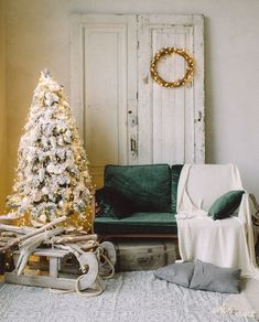 a living room decorated for christmas with a green couch and white tree in the corner