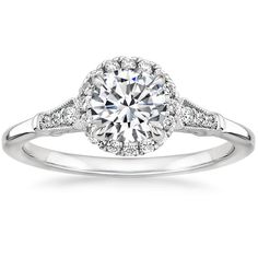 a white gold engagement ring with diamonds on the band and an oval center stone in the middle