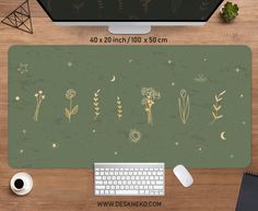 a computer mouse pad with flowers and plants on it next to a keyboard, coffee cup and pen