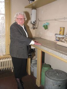 an older woman is standing in the kitchen