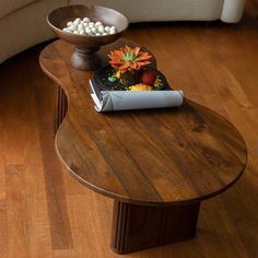 a wooden table topped with a tablet computer next to a vase filled with flowers and marshmallows