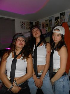 three girls in white shirts and black ties posing for the camera