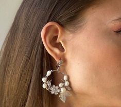 a close up of a person wearing some kind of earring with flowers on it