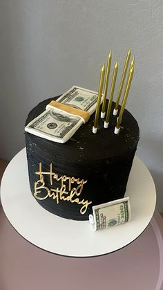 a birthday cake with money and candles on top