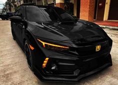 a black sports car parked on the side of a road in front of a building