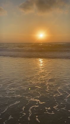 the sun is setting over the ocean with waves