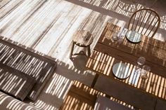 an overhead view of a table with chairs and plates on it, in the sun