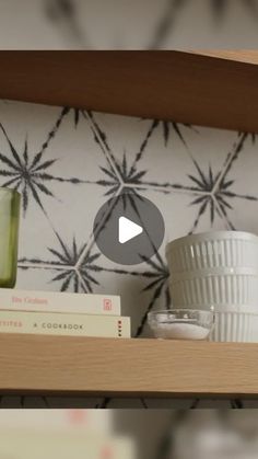 a shelf filled with books and cups on top of it