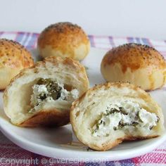 some bread rolls with cheese and spinach on a white plate, ready to be eaten