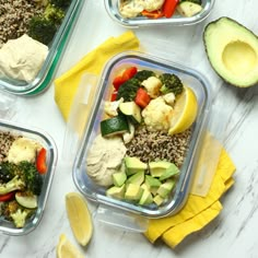 four plastic containers filled with food on top of a white counter next to sliced avocado