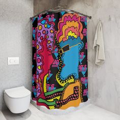 a colorful shower curtain in a bathroom next to a toilet