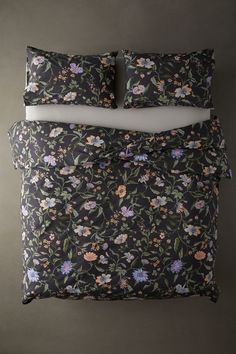 an image of a bed with floral comforter and pillowcases on top of it