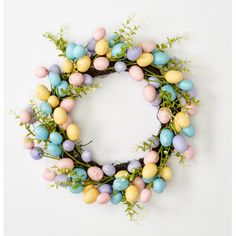 an easter wreath made out of eggs and greenery on a white background with copy space