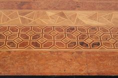 an intricately designed wooden table top with tile work on it's sides and bottom