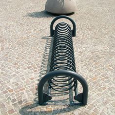 a bench with a hat on top of it sitting in the middle of a cobblestone street