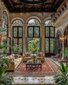 a large living room with lots of windows and plants in it's center area