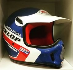 a helmet sits in a white shelf with red, white and blue stripes on it