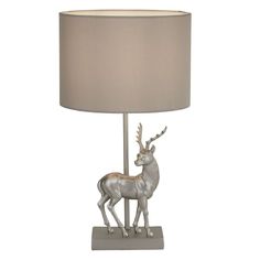 a lamp that has a deer on it with a light shade over the top and bottom