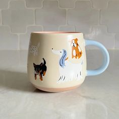 a coffee mug with dogs on it sitting on a counter