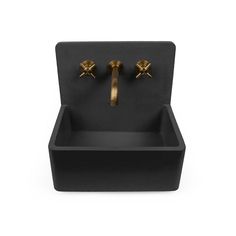 a black sink with two gold faucets on it