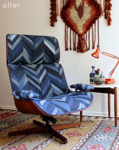 a blue chair sitting on top of a wooden table next to a wall mounted deer head